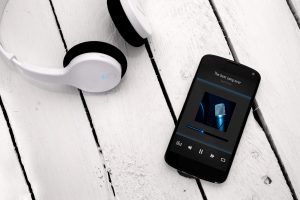 Modern smartphone on the wooden board with bluetooth headphones. ガジェット スマホ レンタル 無料